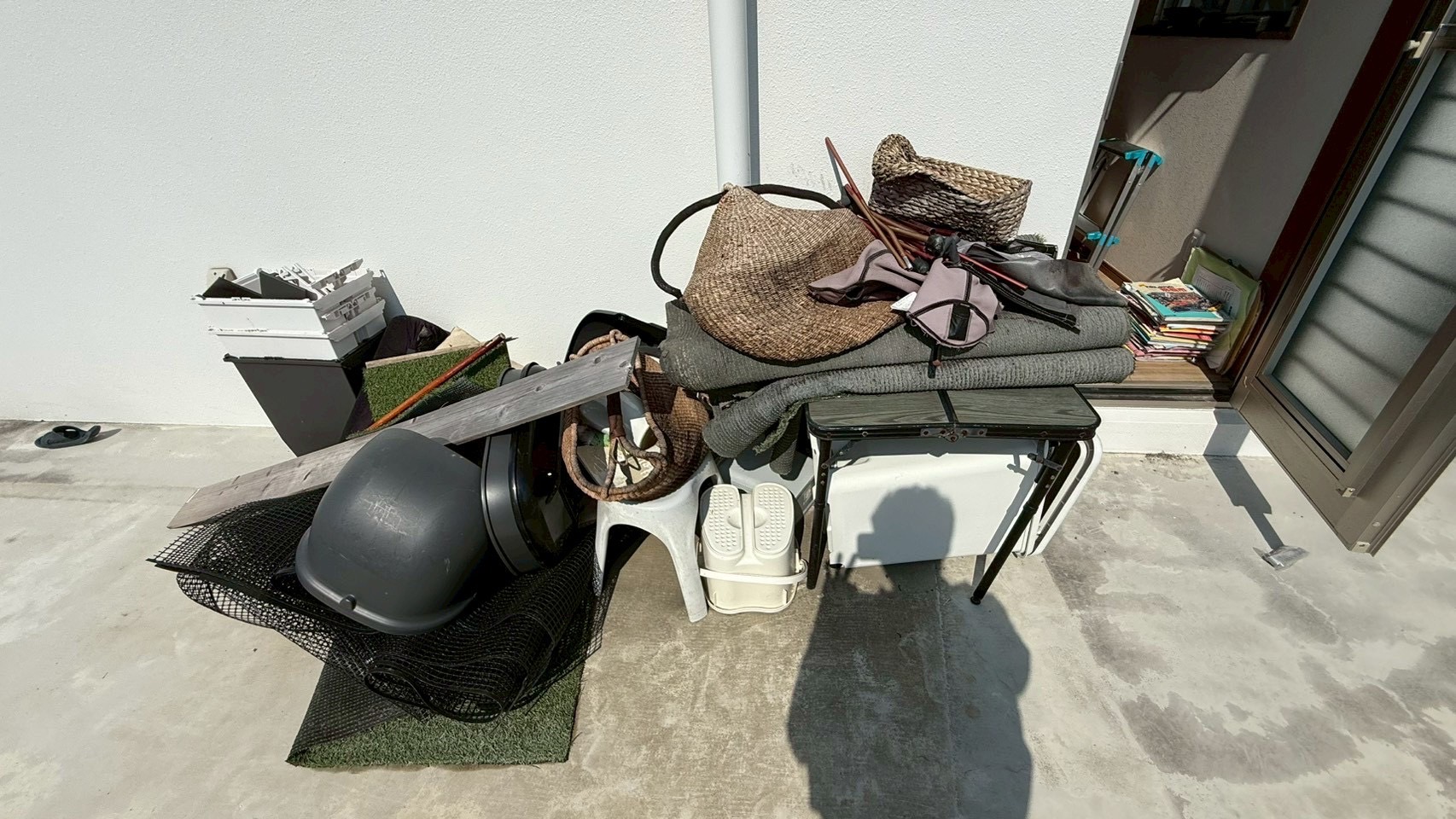 浦添市の回収前の様子（テーブル・椅子・カーペット・籐カゴ・木材・ネット・雑誌などが混在）